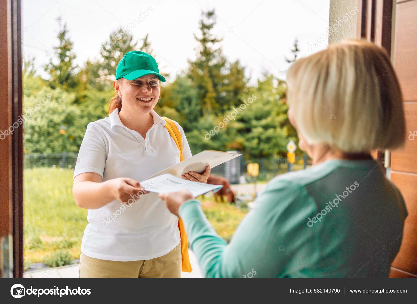 50s Woman Customer Get A Pen Form Delivery Service Woman In Uniform For Signature Receiving Parcel Post Box From Courier At Home, Express Delivery And Shopping Online Concept